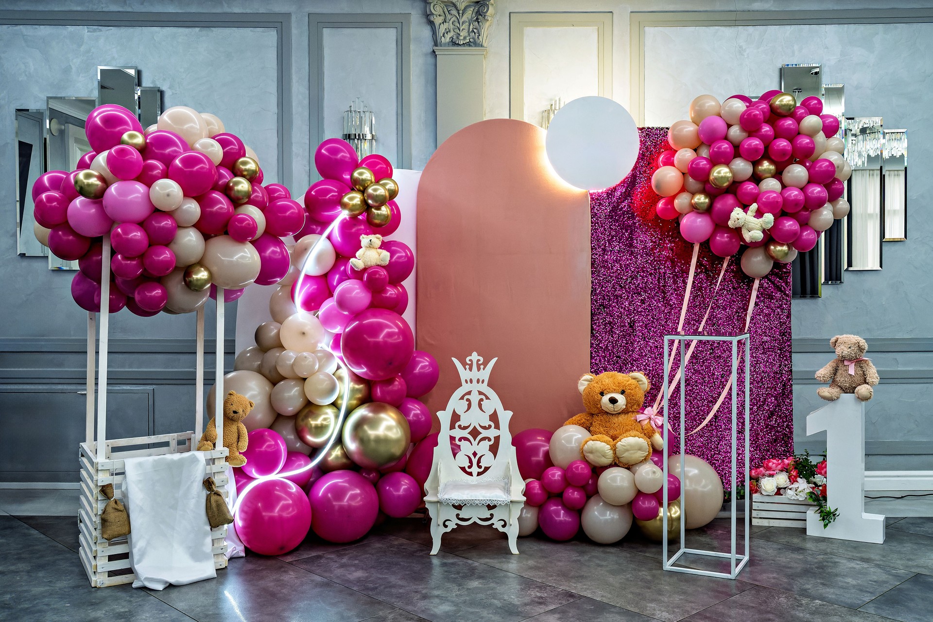 A pink and gold baby shower with balloons and teddy bears